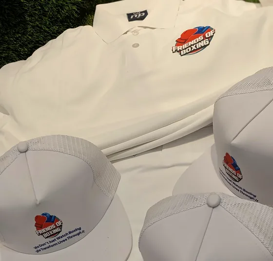 White polo shirts and caps printed with the Friends of Boxing logo.