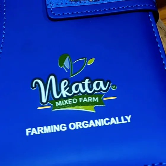 Blue notebook printed with the Nkata Mixed Farm logo and Farming Organically.