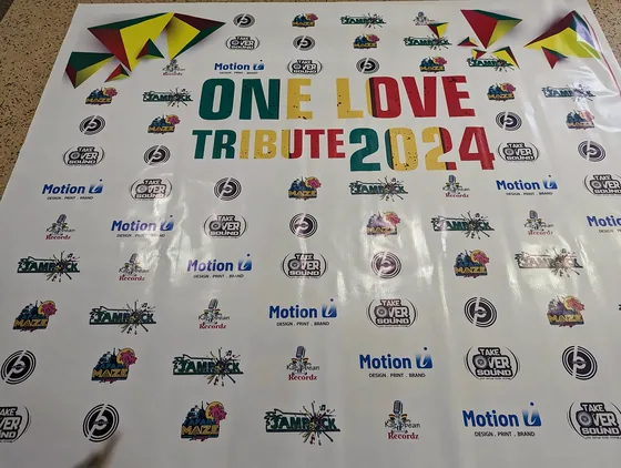 Step-and-repeat backdrop for One Love Tribute 2024 with sponsor logos.
