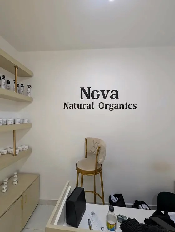 Nova Natural Organics lettering on a white wall above a small seating area.